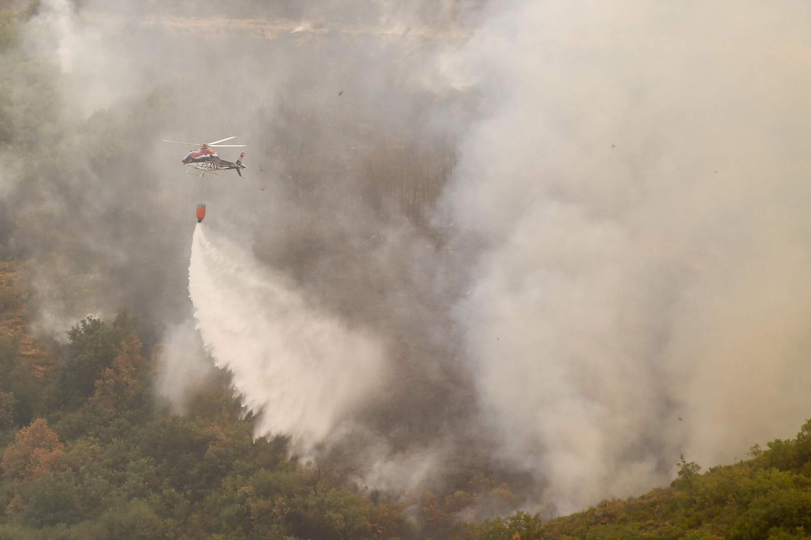 Un helicóptero descarga agua en el incendio de Porto.