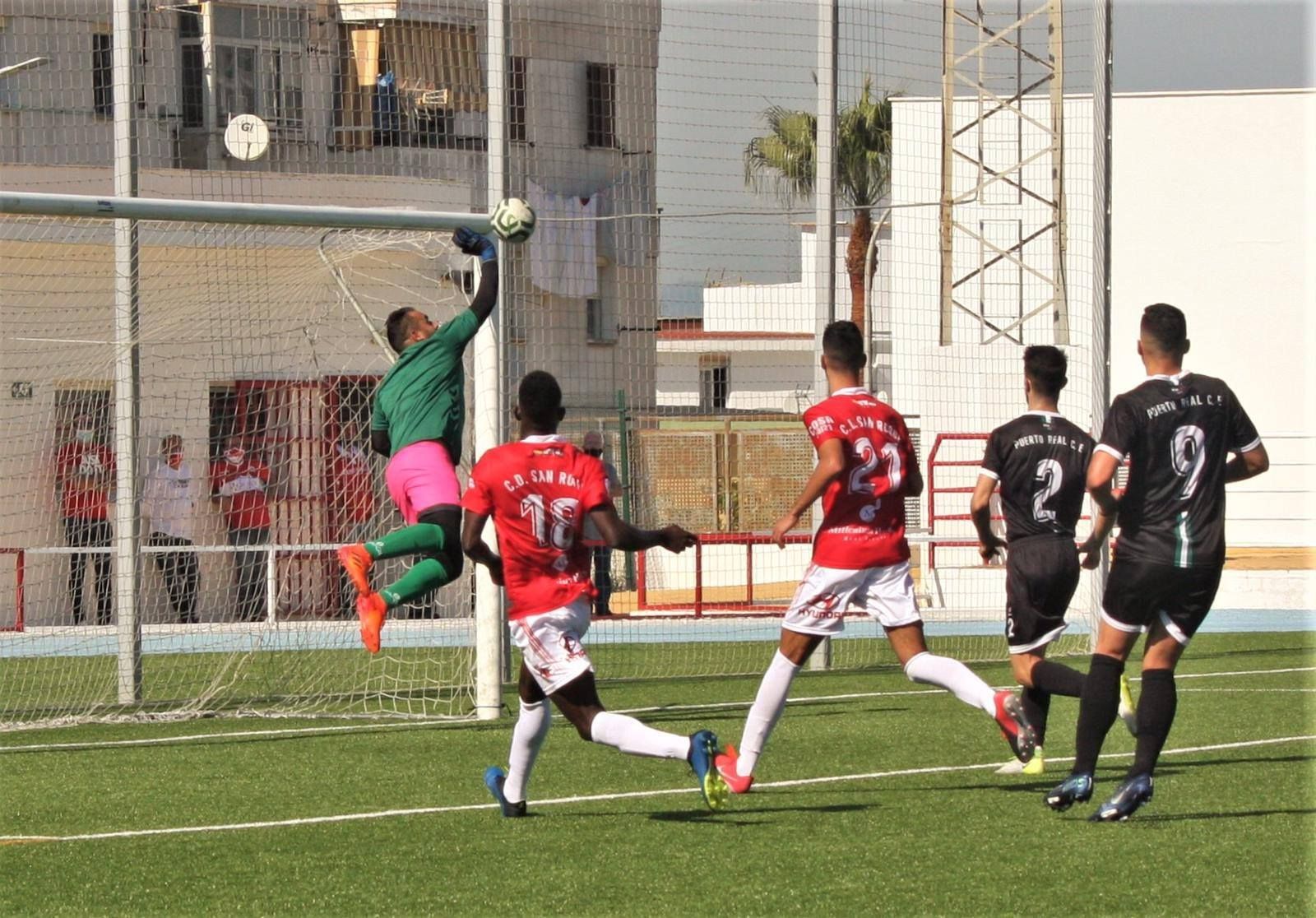 Rafa, portero del Puerto Real, vuela hacia una escuadra para despejar un balón.
