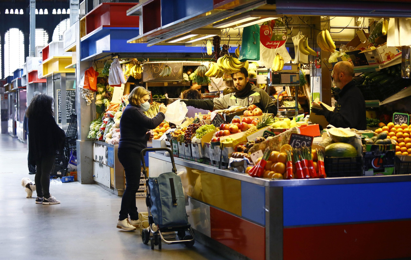 Una mujer compra fruta en uno de los tradicionales mercados de abastos de Málaga.
