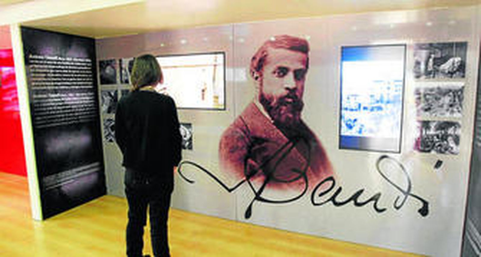 Una visitante contempla una de las pantallas que pueden observarse en el interior del bus de Caixa Catalunya sobre Gaudí.