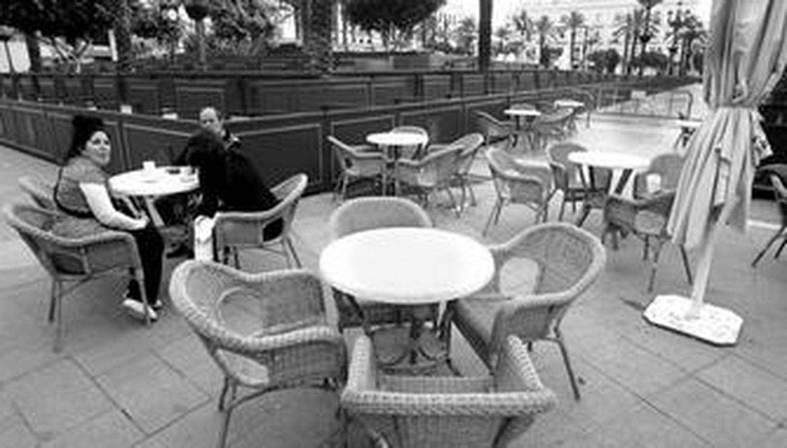 Un grupo de personas en una de las mesas de la Ibense con el paisaje de fondo de los palcos, instalados ya para Semana Santa.