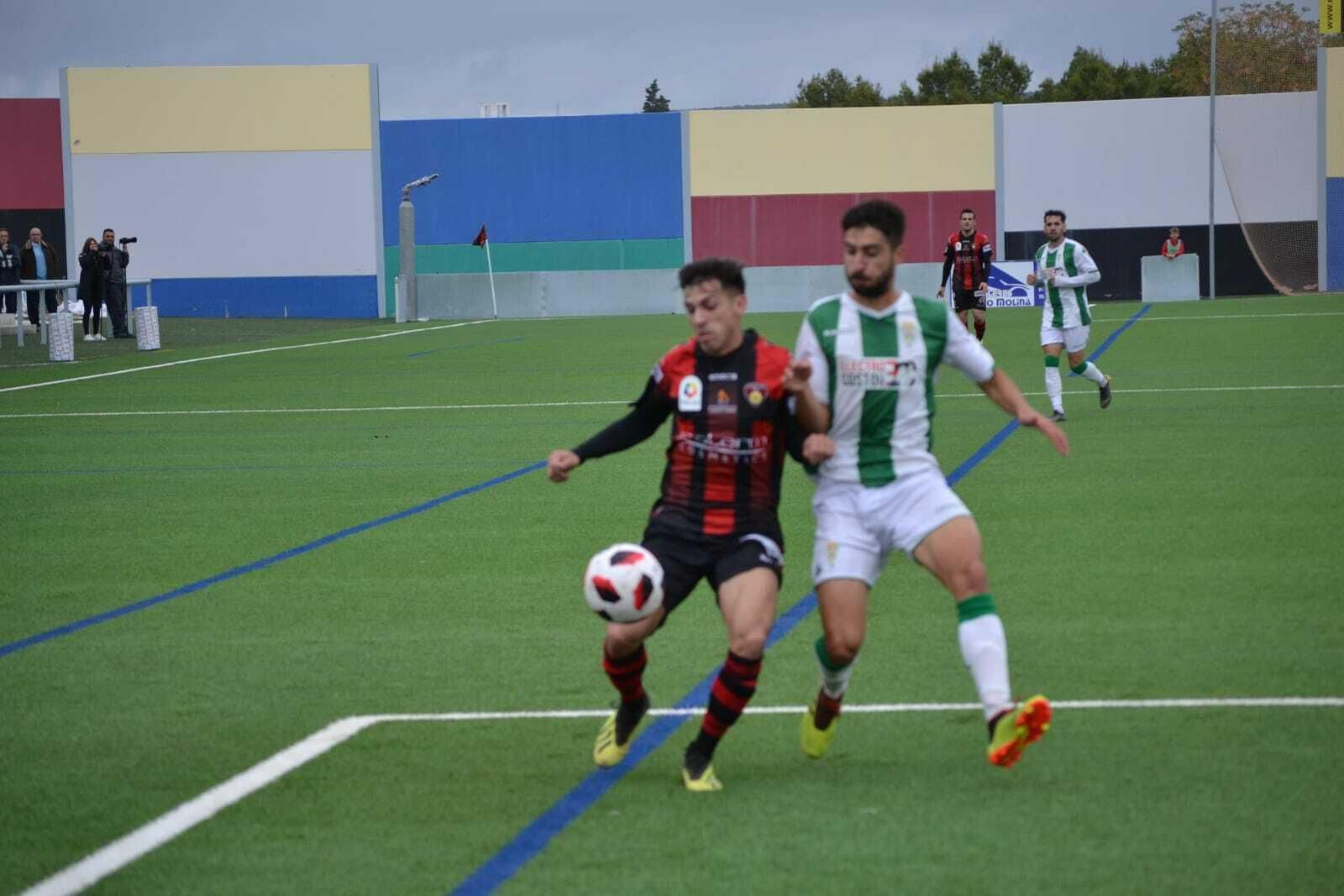 Un jugador del Salerm Puente Genil controla el balón ante un jugador del Córdoba B.