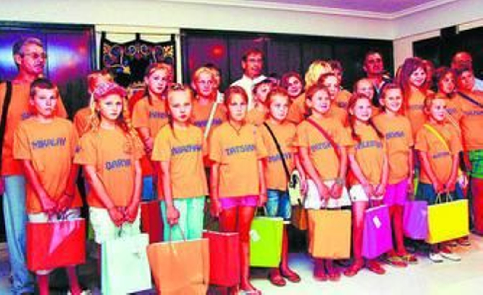 Un grupo de niños bielorrusos posan junto a miembros de la asociación Sanicher.