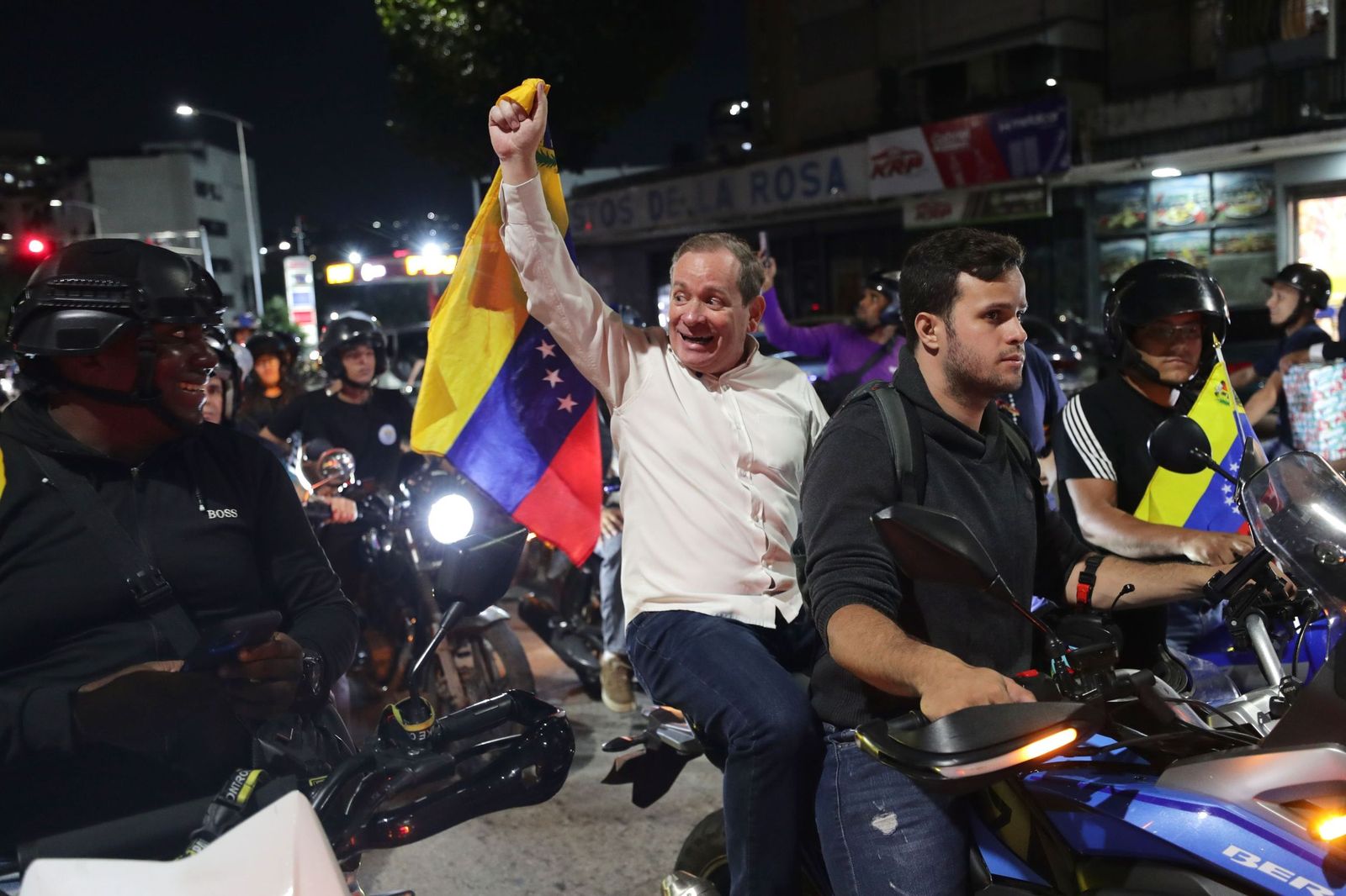 El opositor Juan Pablo Guanipa sostiene una bandera de Venezuela en una manifestación en Caracas tras ser liberado.