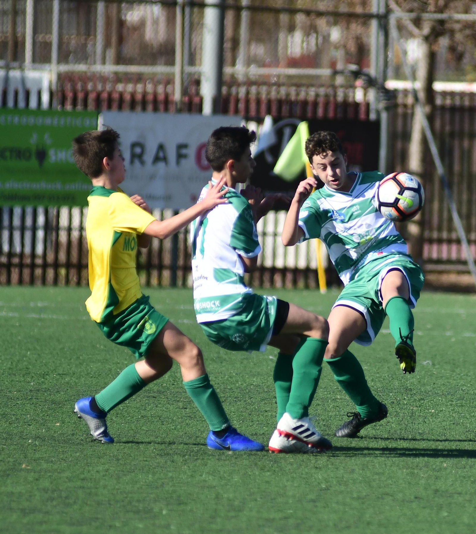 Un jugador del Apedem Montilla trata de frenar el despeje de uno del Juanín y Diego.