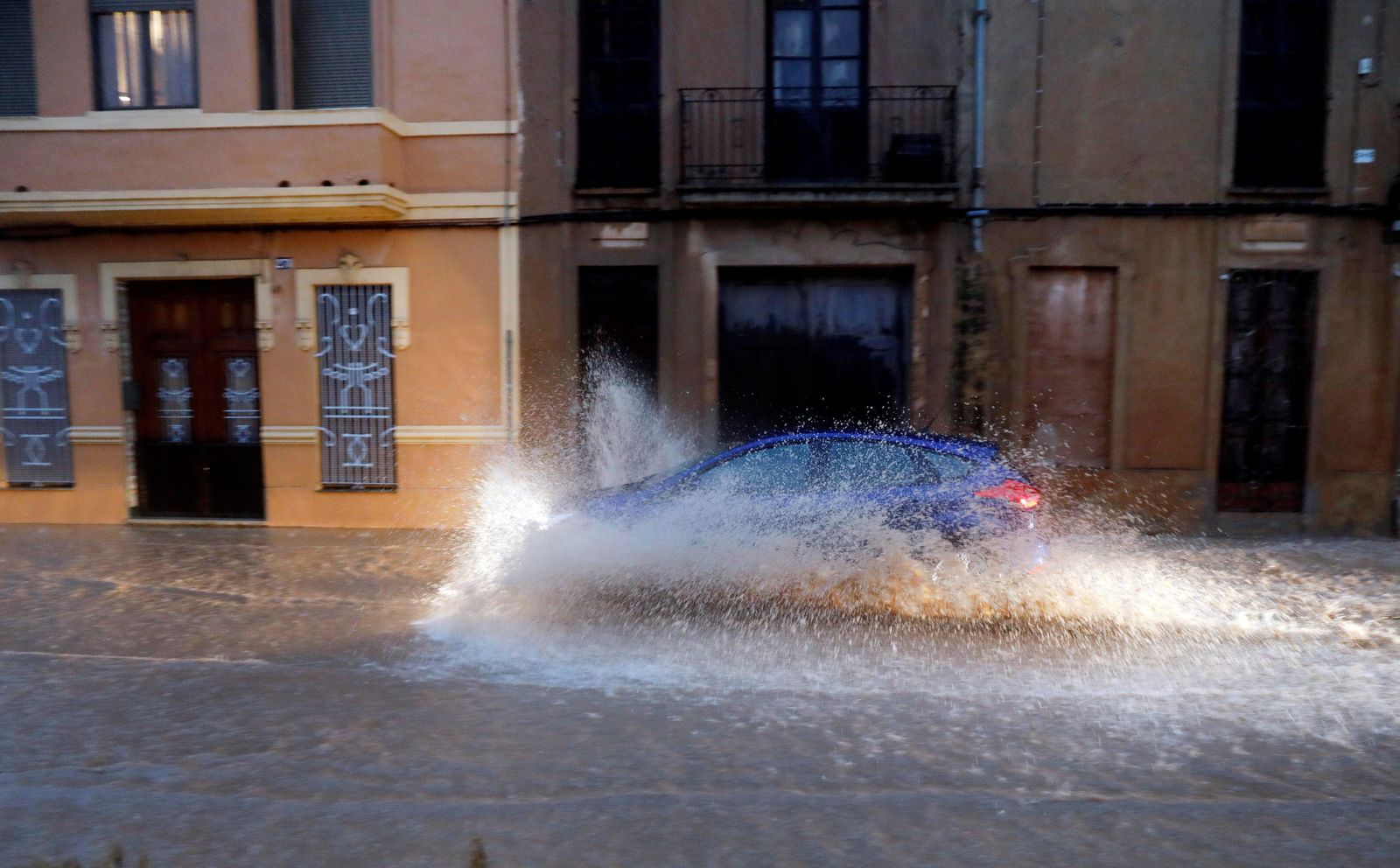 Un coche atraviesa una balsa de agua tras las fuertes lluvias.