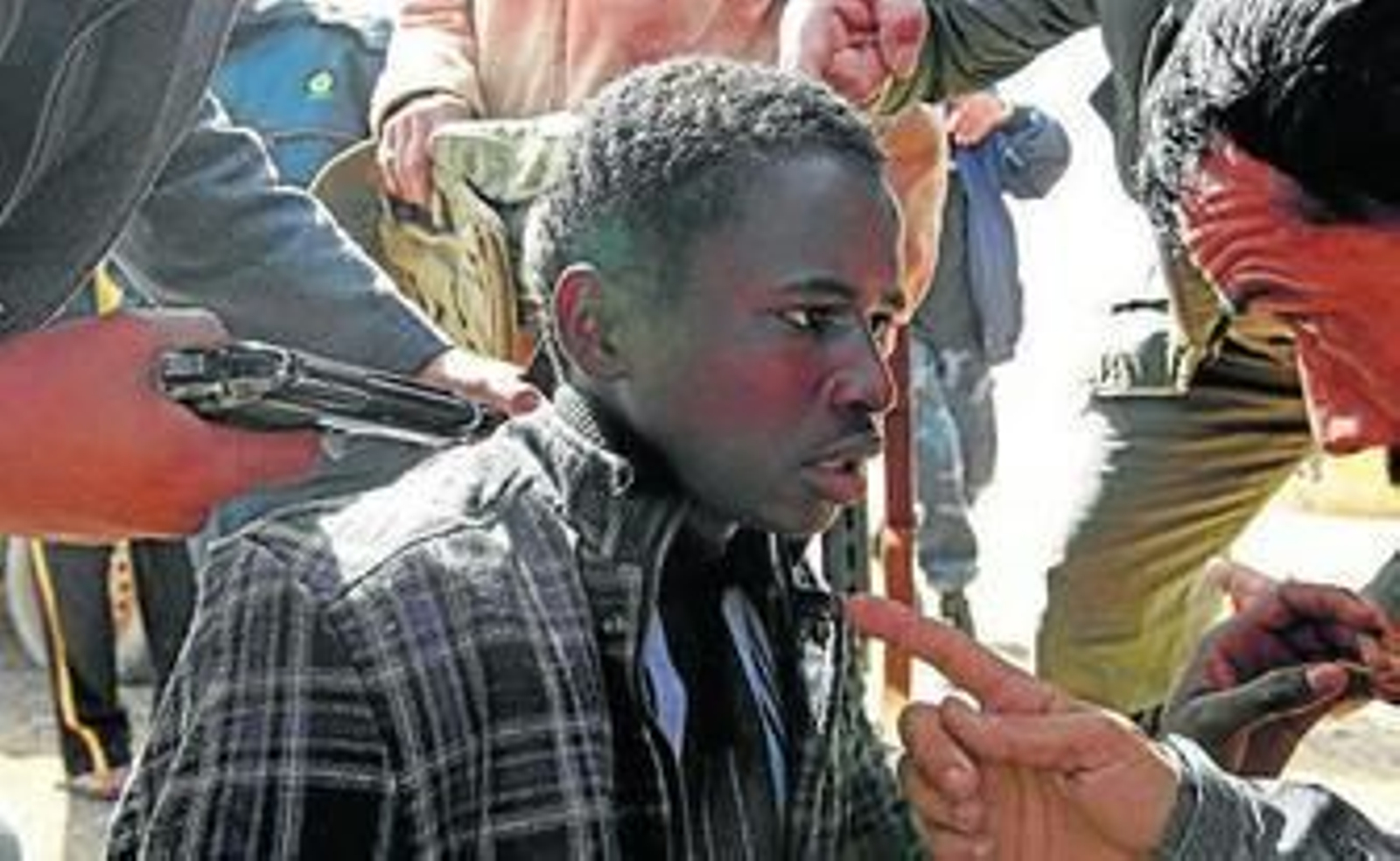 Rebeldes apuntan a un hombre al que acusan de ser un mercenario.