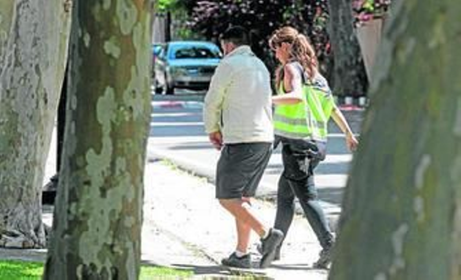Una agente con uno de los detenidos, ayer en la puerta de la vivienda de la avenida de Las Golondrinas.