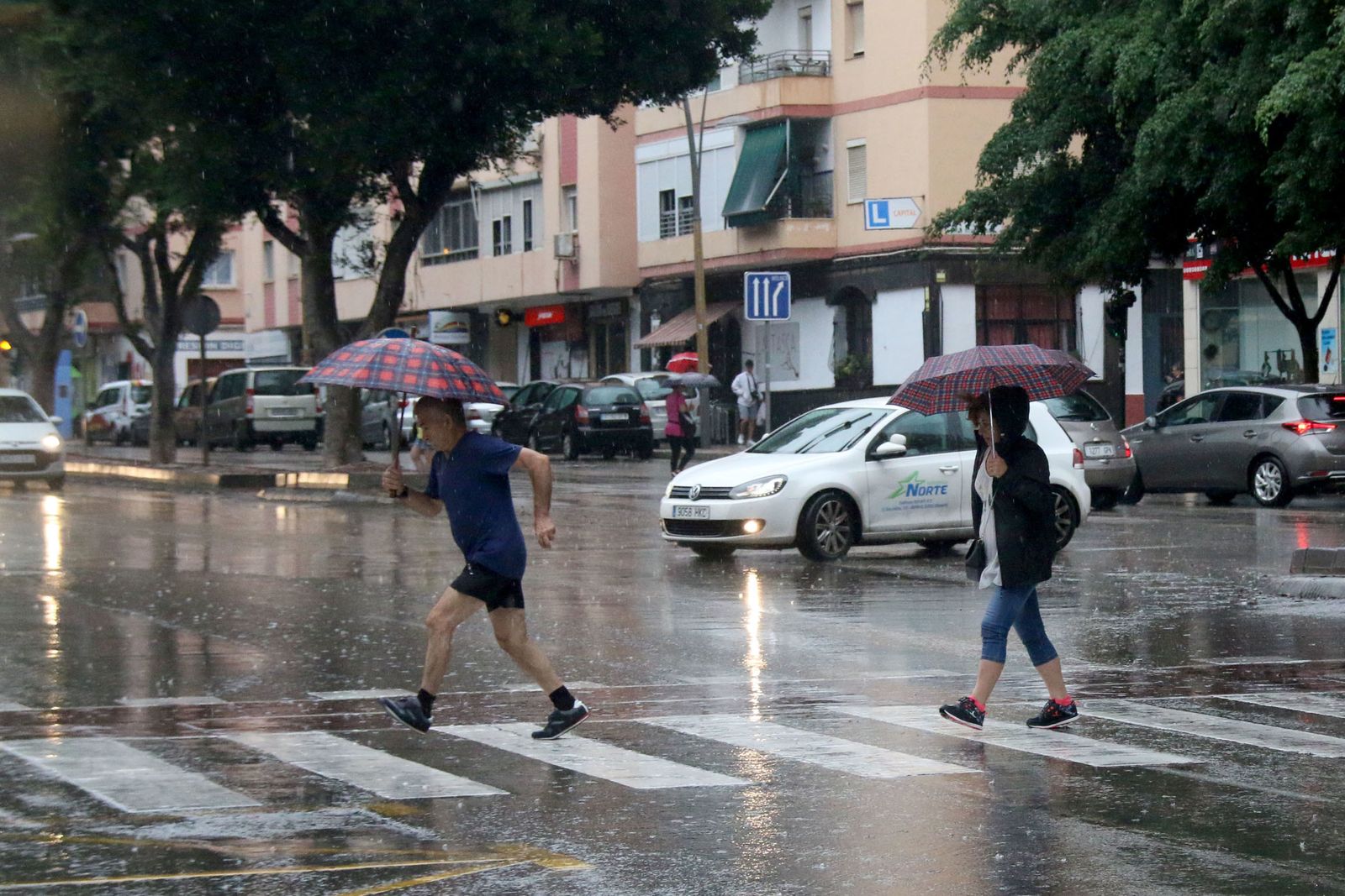 Transeuntes bajo el chaparrón.