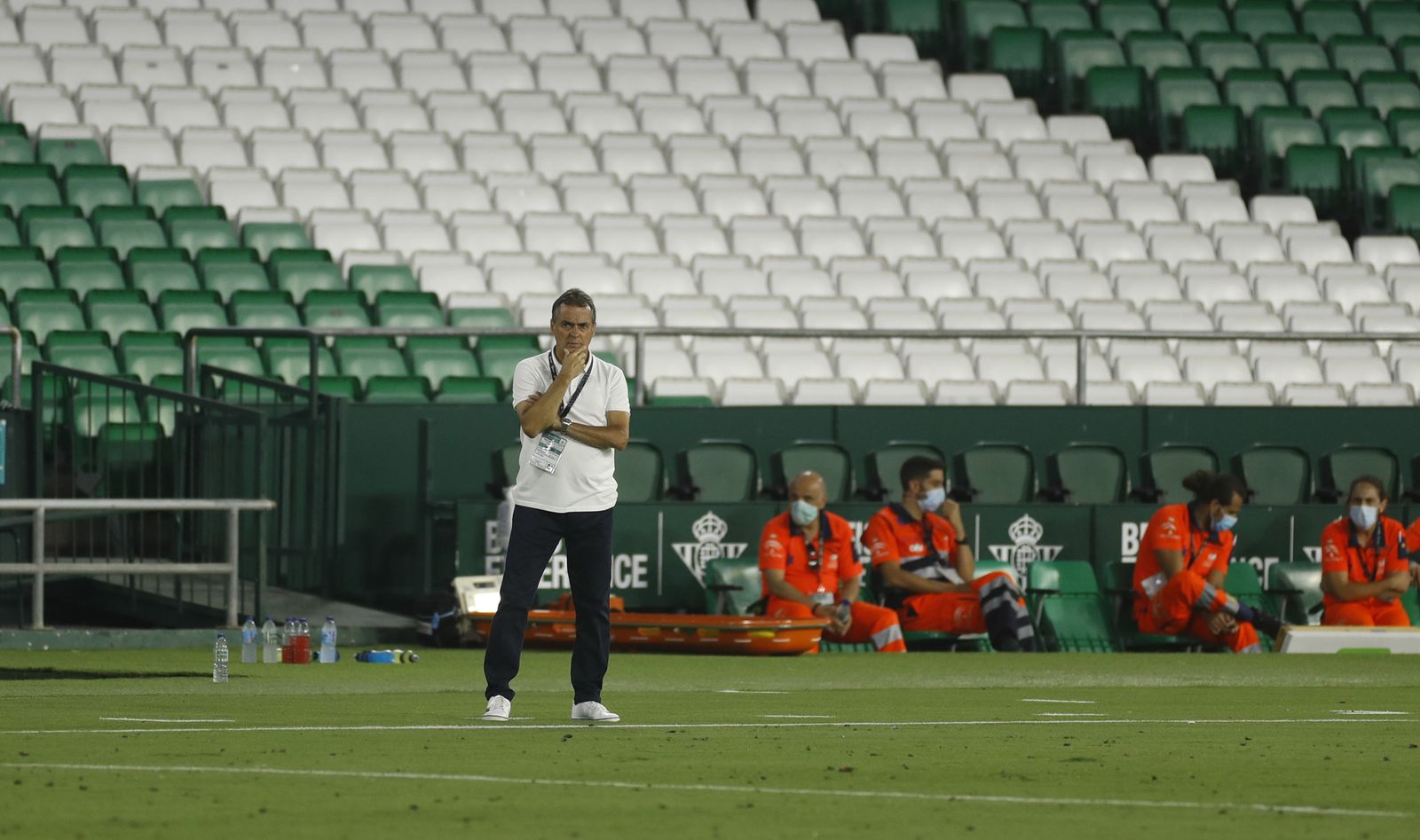 Alexis, con gesto de preocupación, ante el banquillo y la vacía grada del Benito Villamarín.