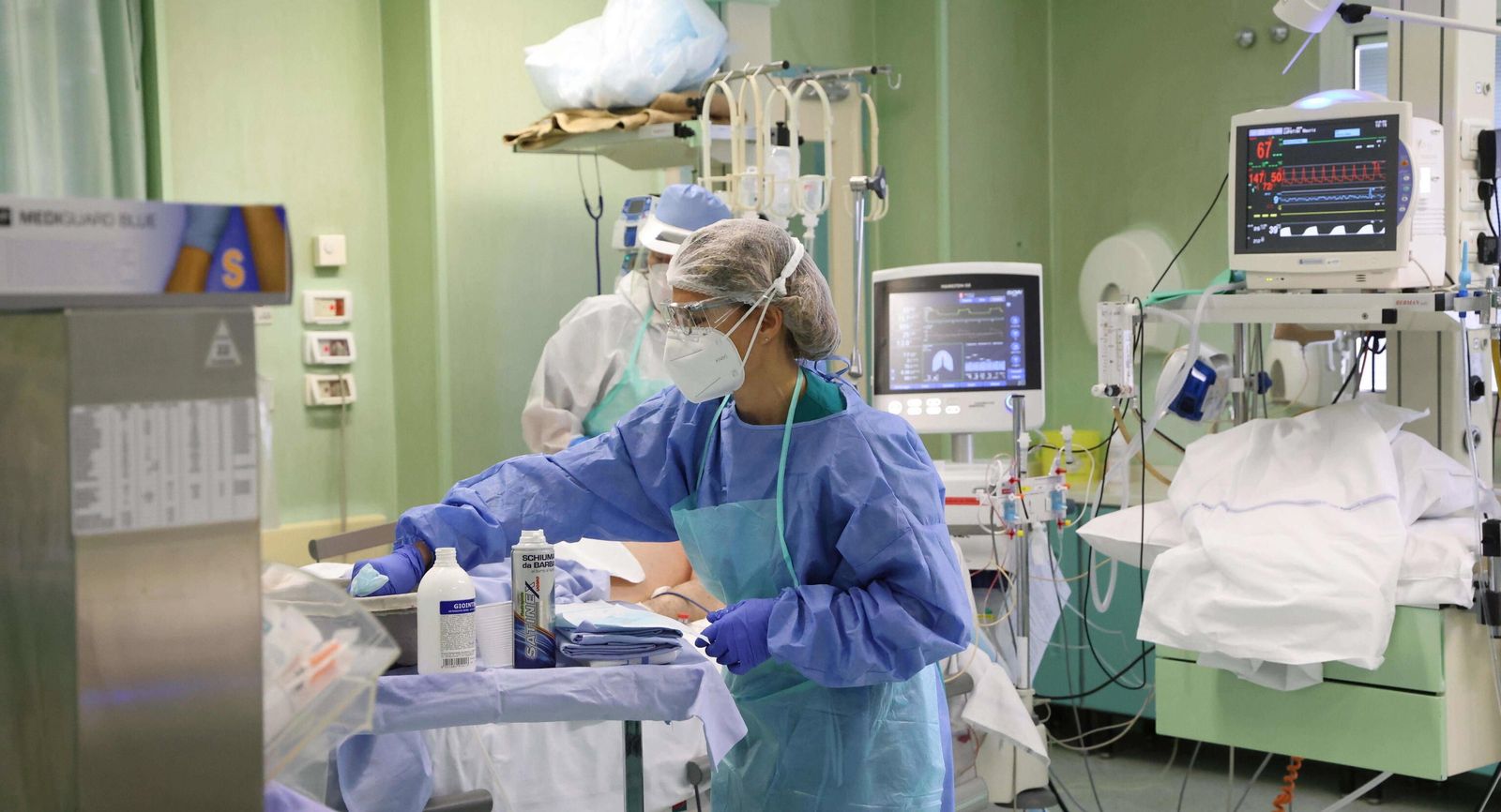 Dos profesionales sanitarias atienden a un paciente ingresado en una UCI covid.