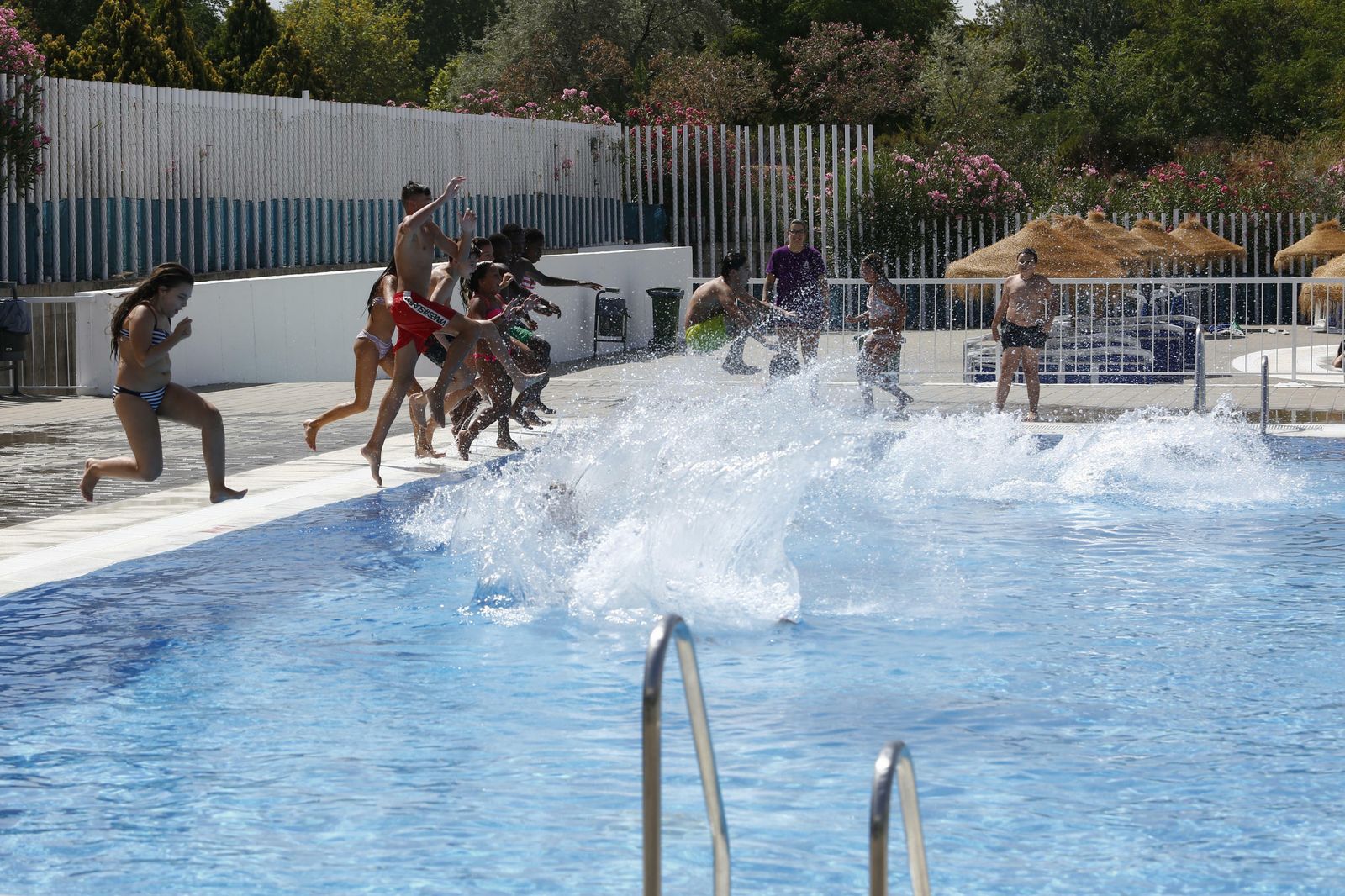 Usuarios de la piscina de Almanjáyar disfrutan de la instalación saltando al agua