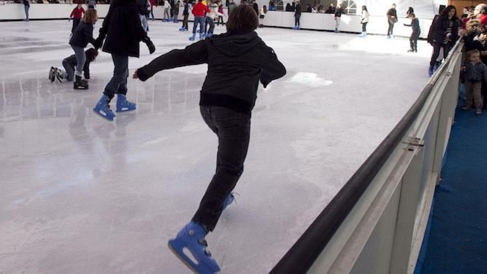 Un niño patina sobre una pista de hielo.