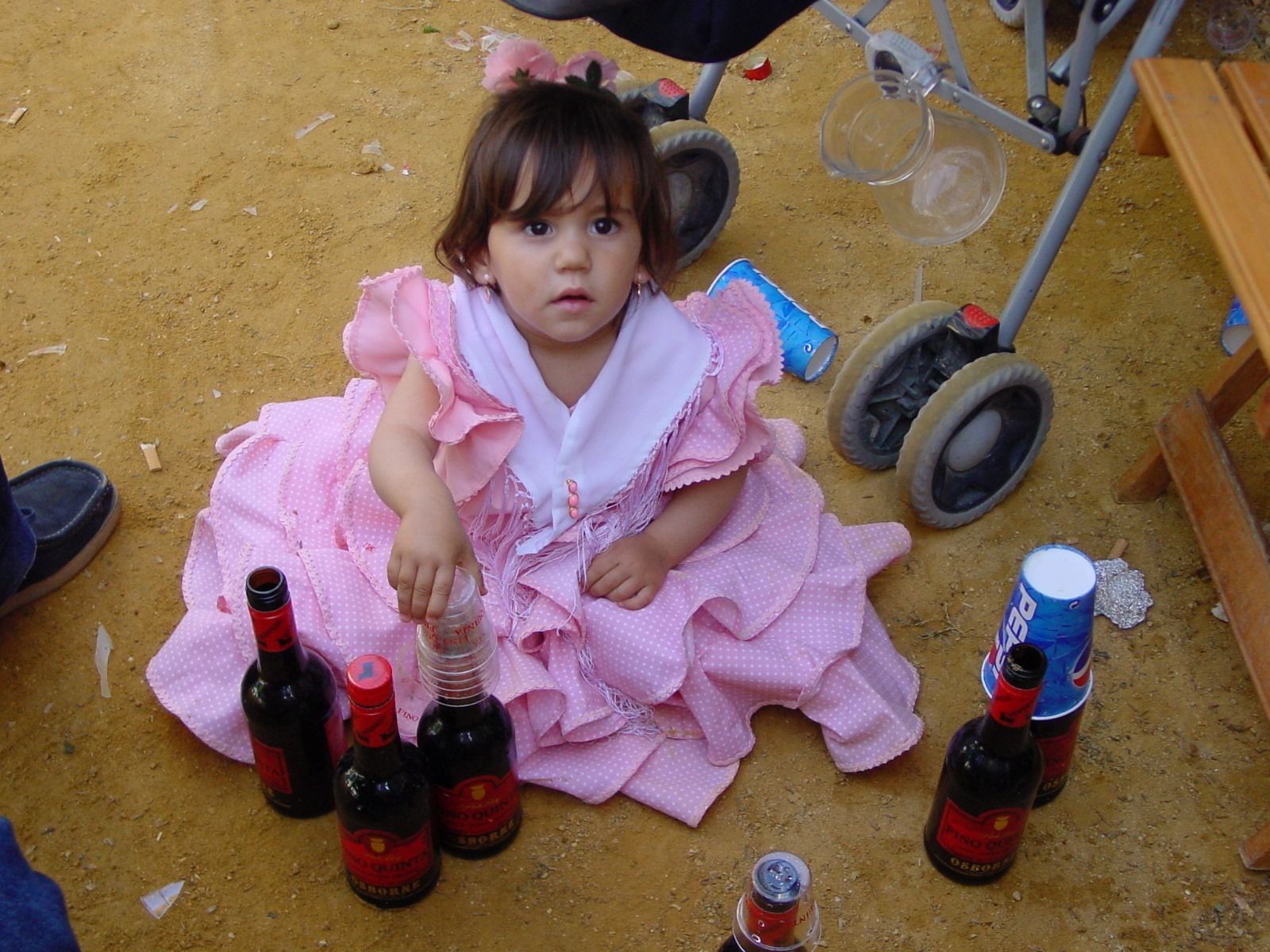 Una niña jugando en la Feria con medias botellas de fino, en una imagen de archivo.