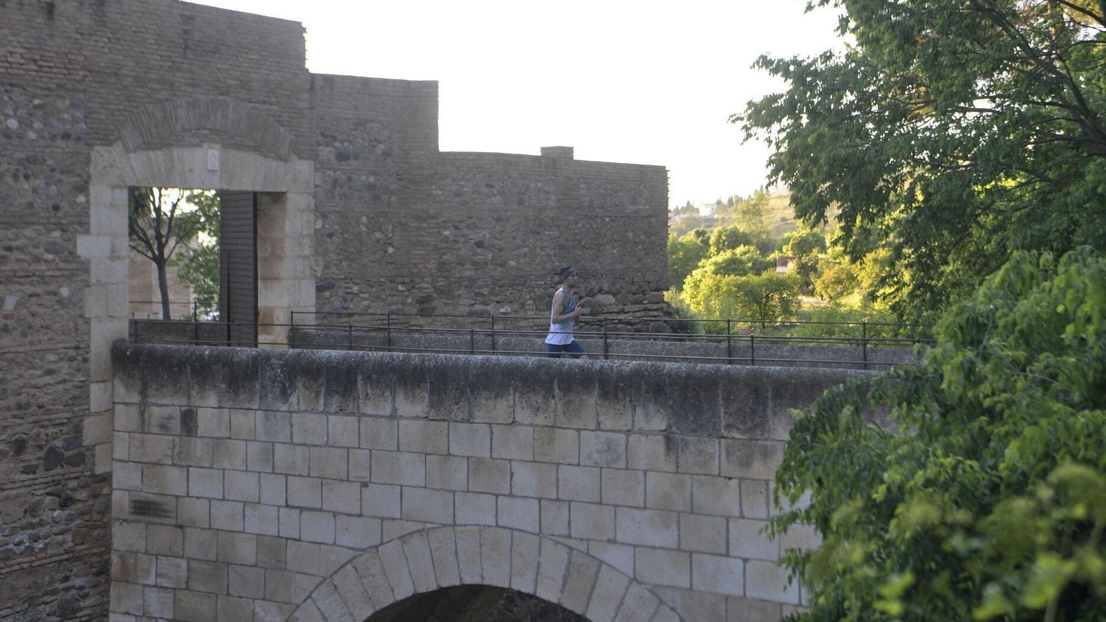 Un atleta pasa por el puente de la Torre del Agua
