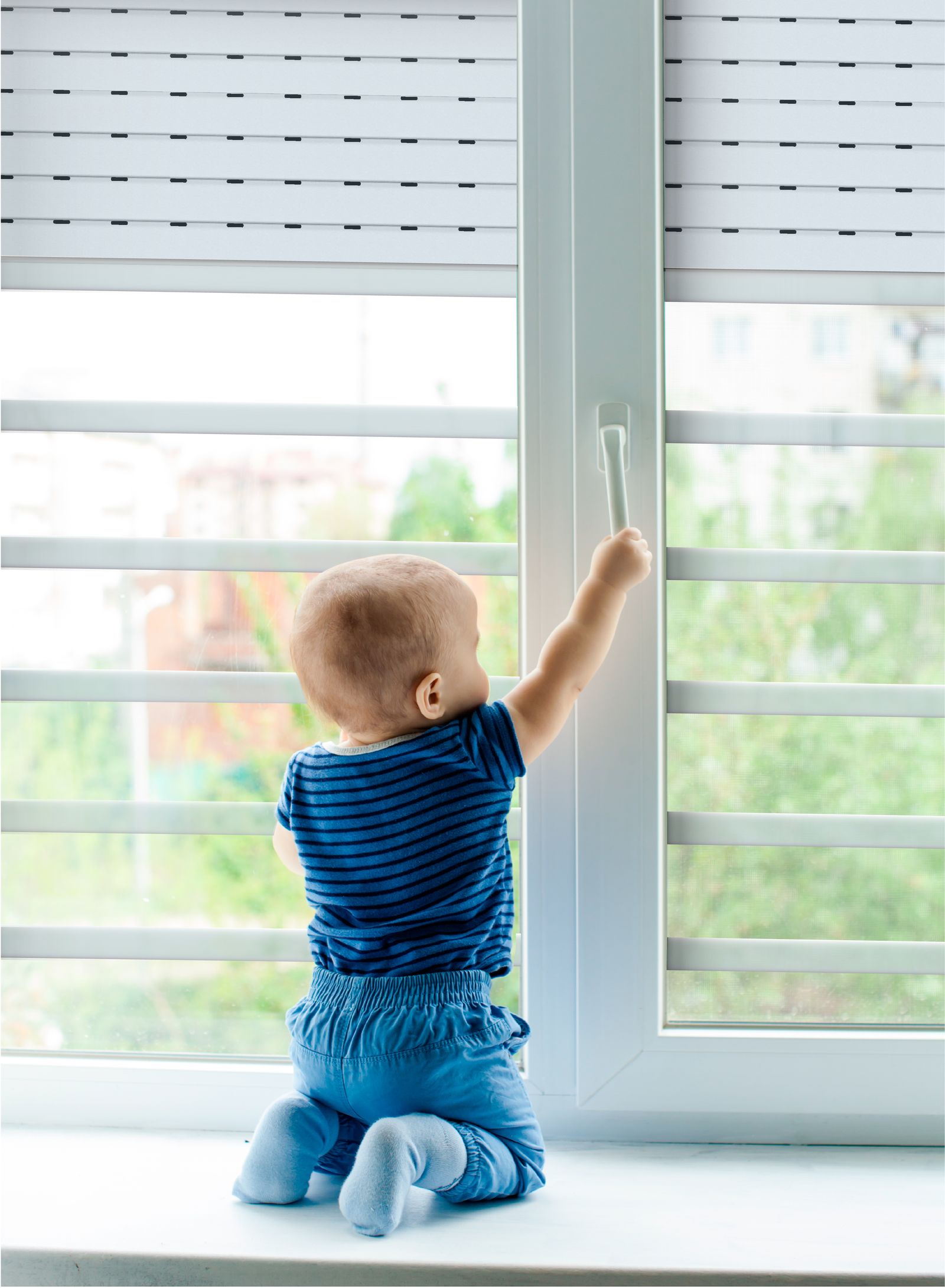 Un niño intenta abrir una ventana que ya tiene el dispositivo de Secupeke colocado.