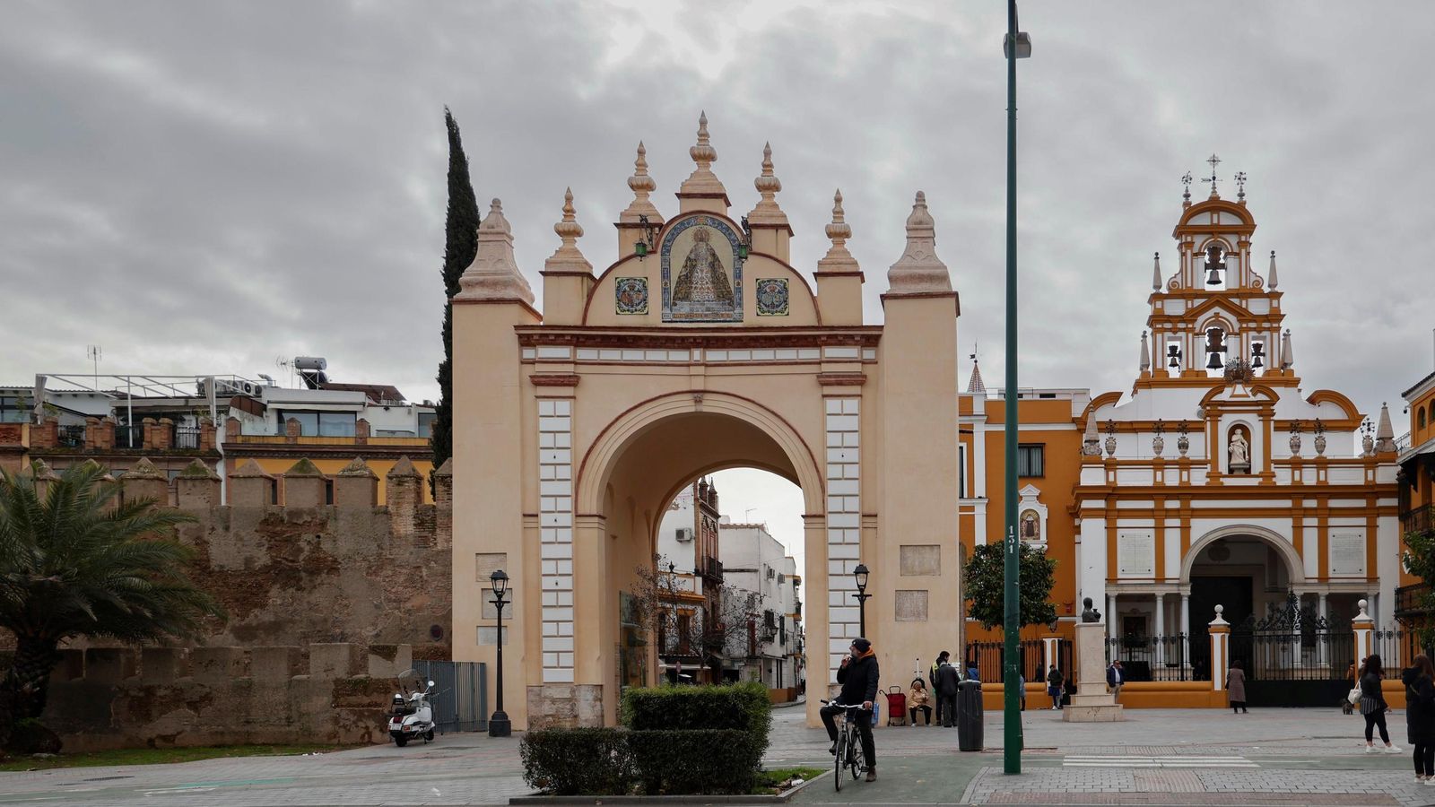 La entrada a la calle San Luis por el Arco de la Macarena con la muralla, a la izquierda, y la basílica de la Macarena, a la derecha.