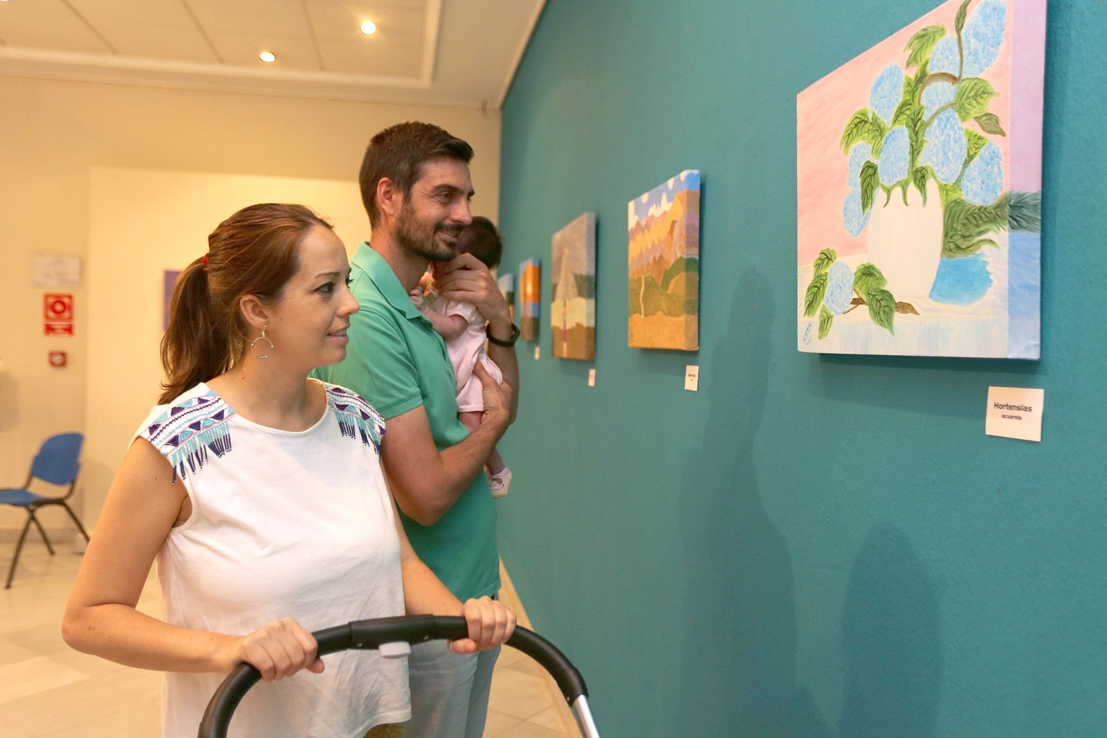 Un matrimonio observa los trabajos a la artista local.