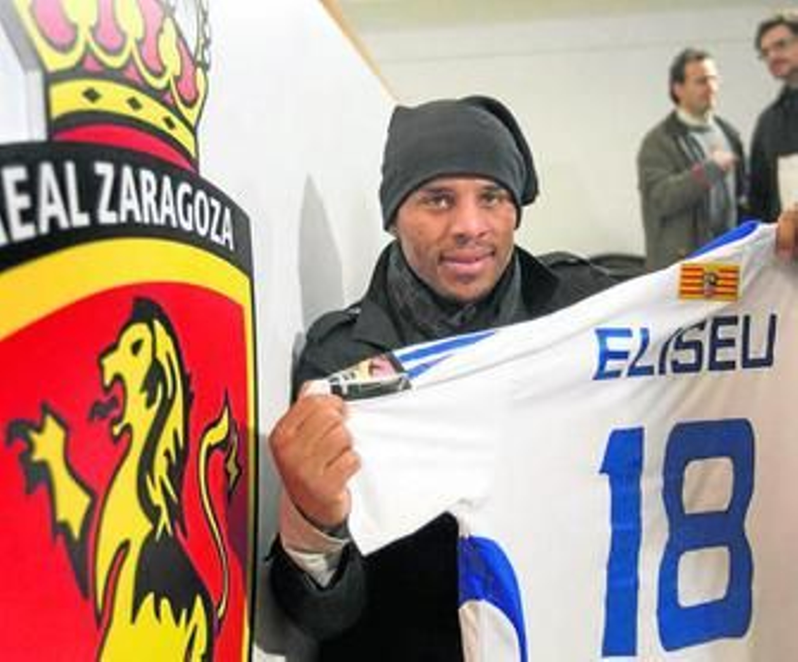Eliseu posa con su nueva camiseta junto al escudo del Zaragoza, ayer.