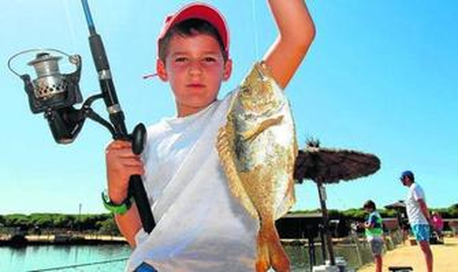 1. Una niña intenta capturar una dorada en uno de los esteros de Salinas del Astur. 2. Ambiente familiar entre los visitantes del lugar. 3. Mientras unos pescan, otros disfrutan de un paseo en canoa. 4. Un pequeño pescador muestra