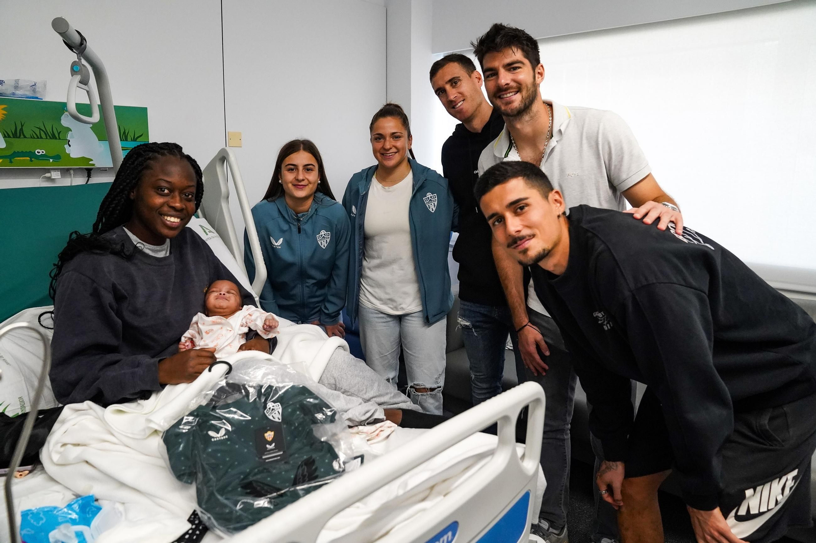 Jugadores y jugadoras junto a un bebé y su madre