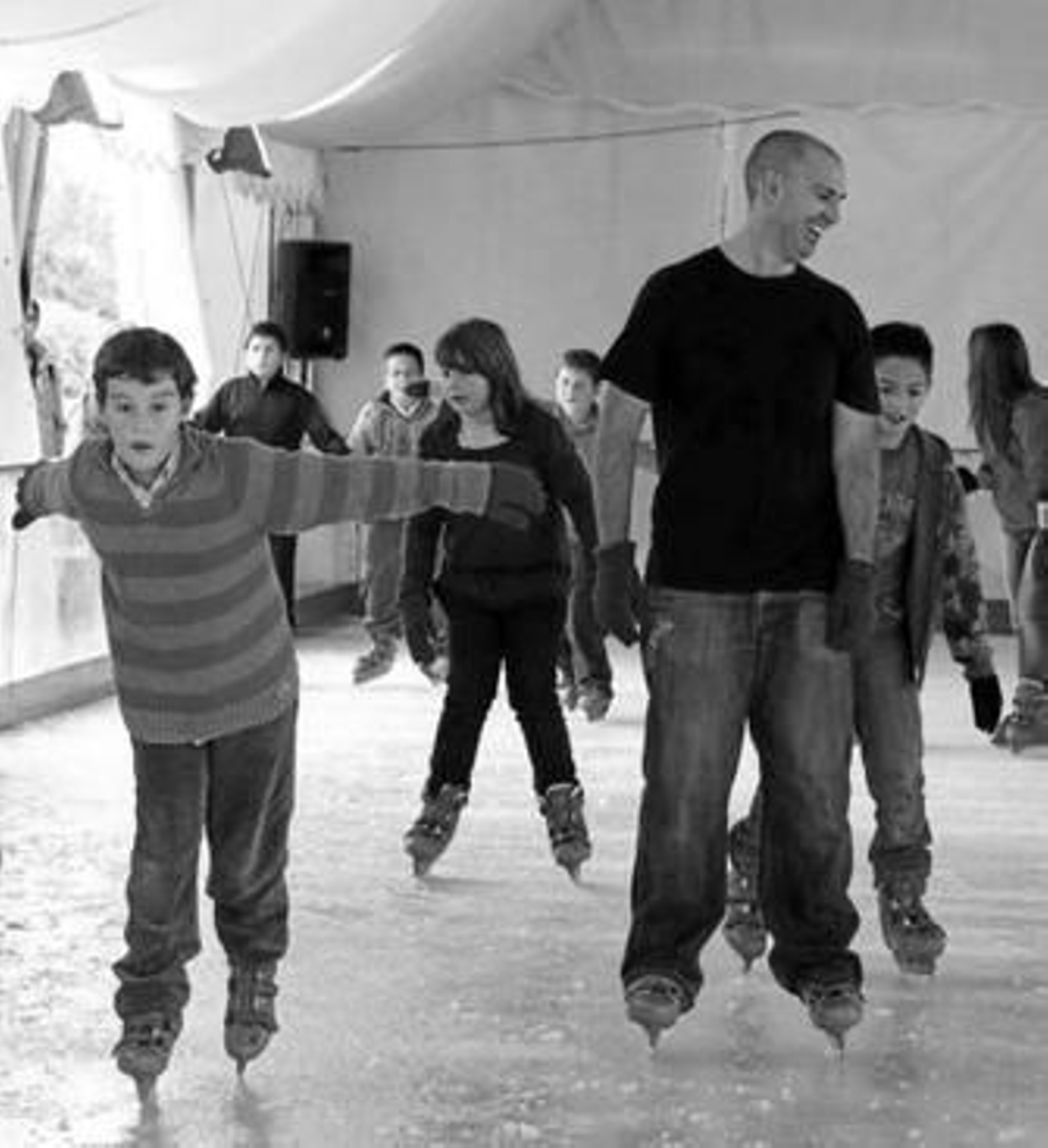 Unos niños y un joven disfrutan de la pista de hielo, ayer.