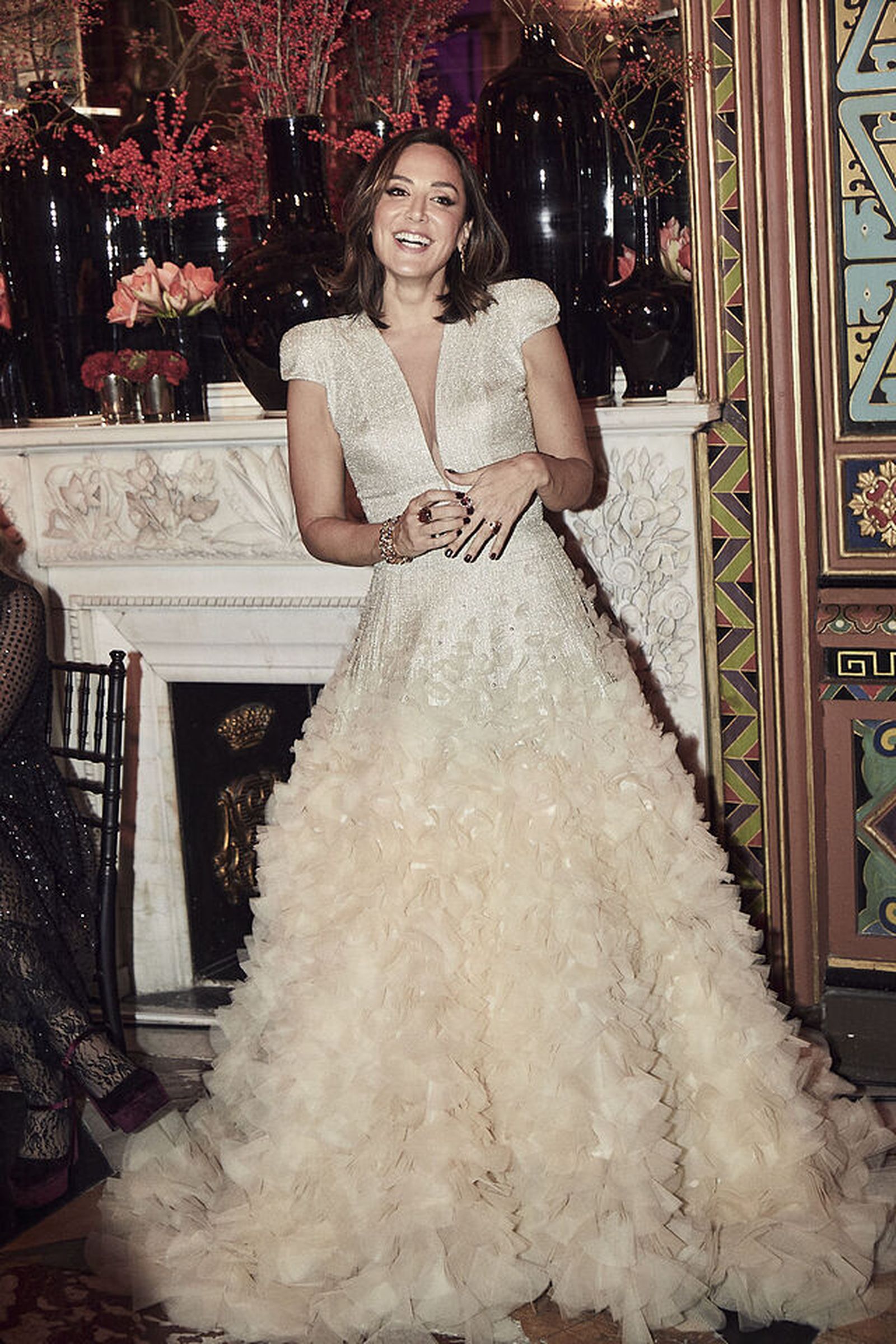 La homenajeada celebró su aniversario con un diseño de aires nupciales firmado por Jan Tamniau en color champán con cuerpo ceñido, escote en forma de V y falda de tul de seda rematada en una larga cola. Lo acompañó de joyas de Tous.