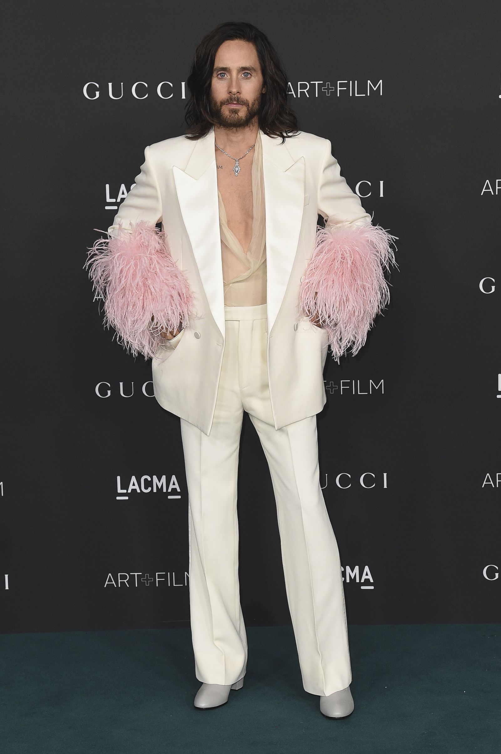 Jared Leto, con traje blanco con plumas rosa.