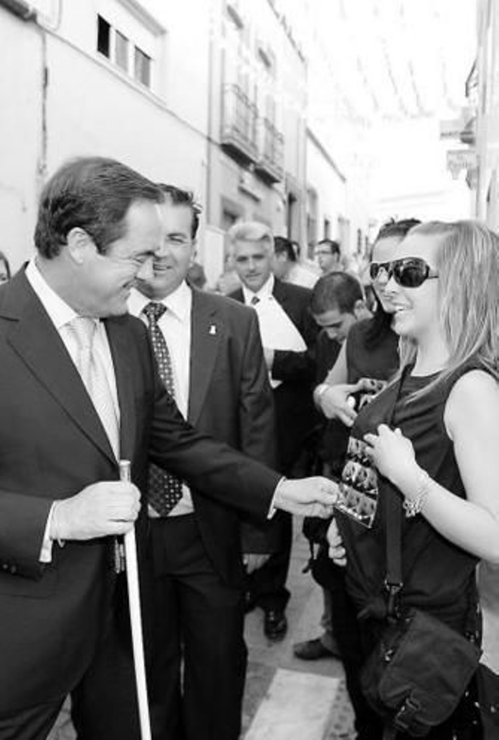 Una joven saluda a José Bono durante la procesión cívica.