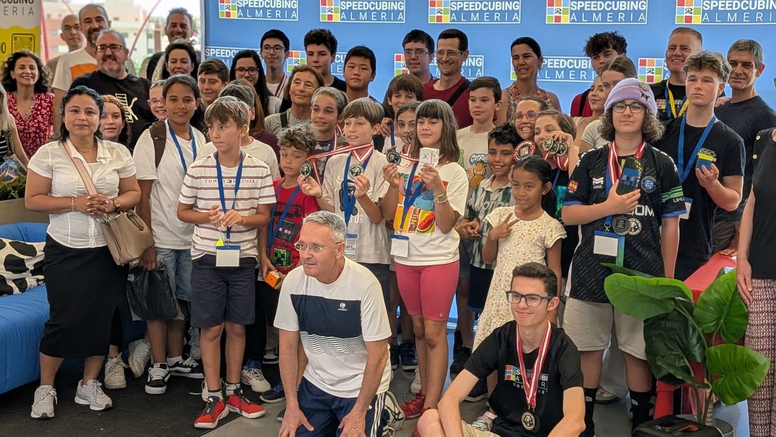 Los jóvenes participantes posan con sus medallas en la foto de familia.