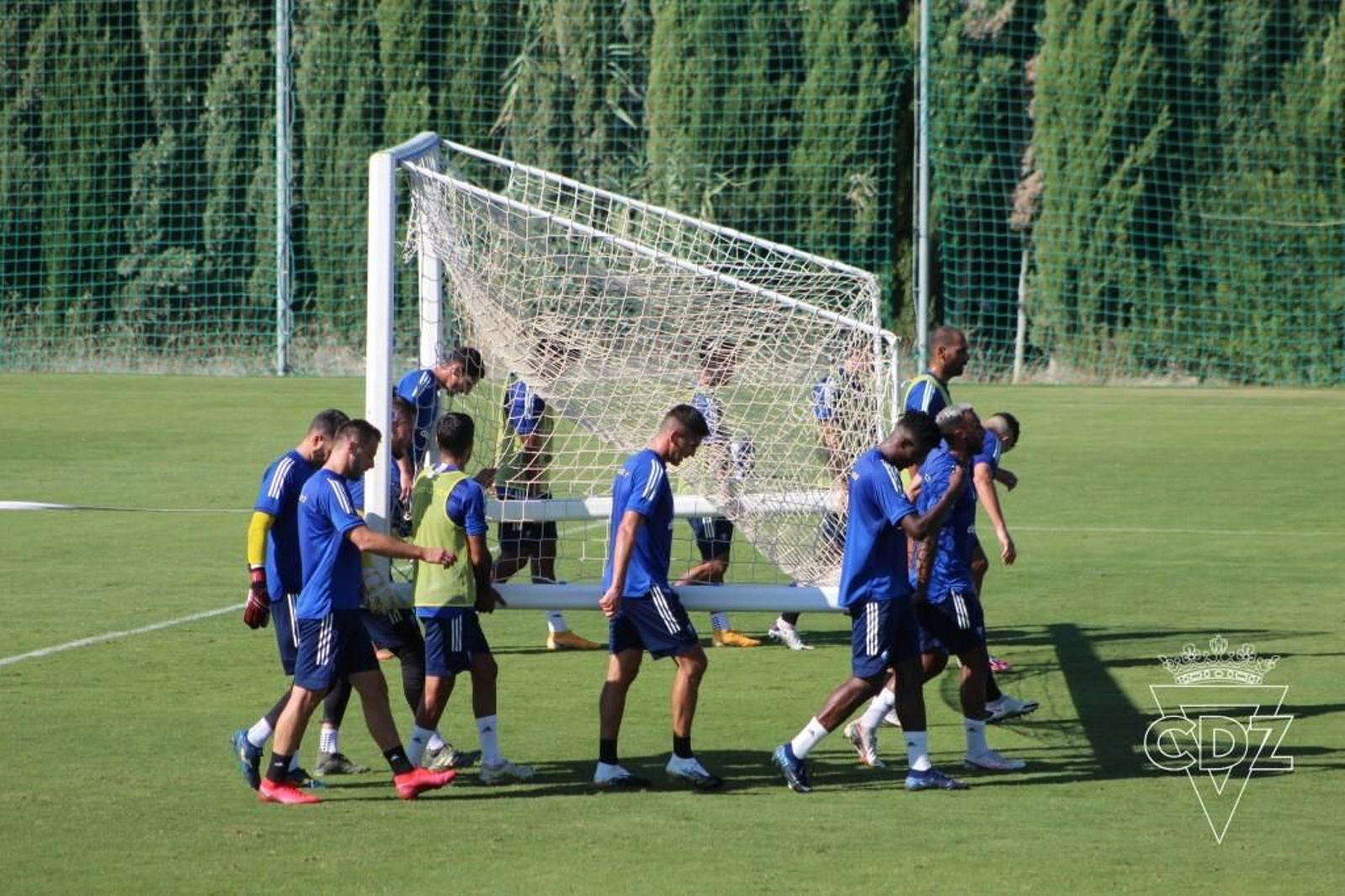 Los jugadores del Cádiz trasladan una portería.
