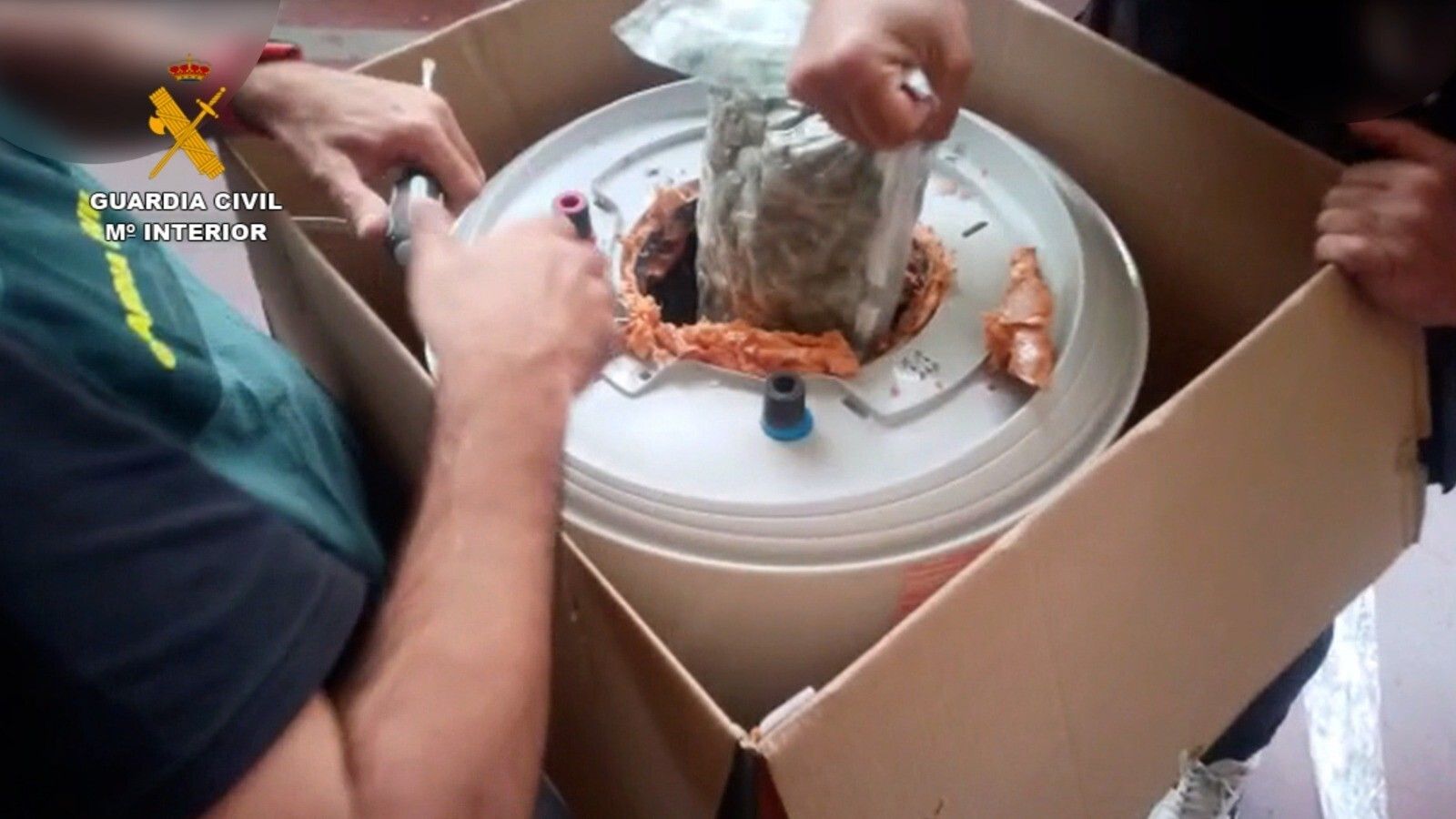 Los agentes extraen droga de un termo de agua incautado.