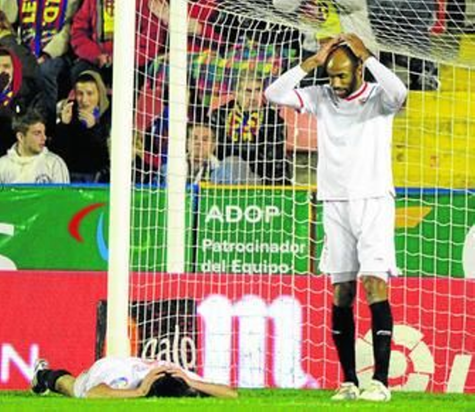 Spahic en el suelo y Kanoute de pie se lamentan tras la ocasión de aquél.