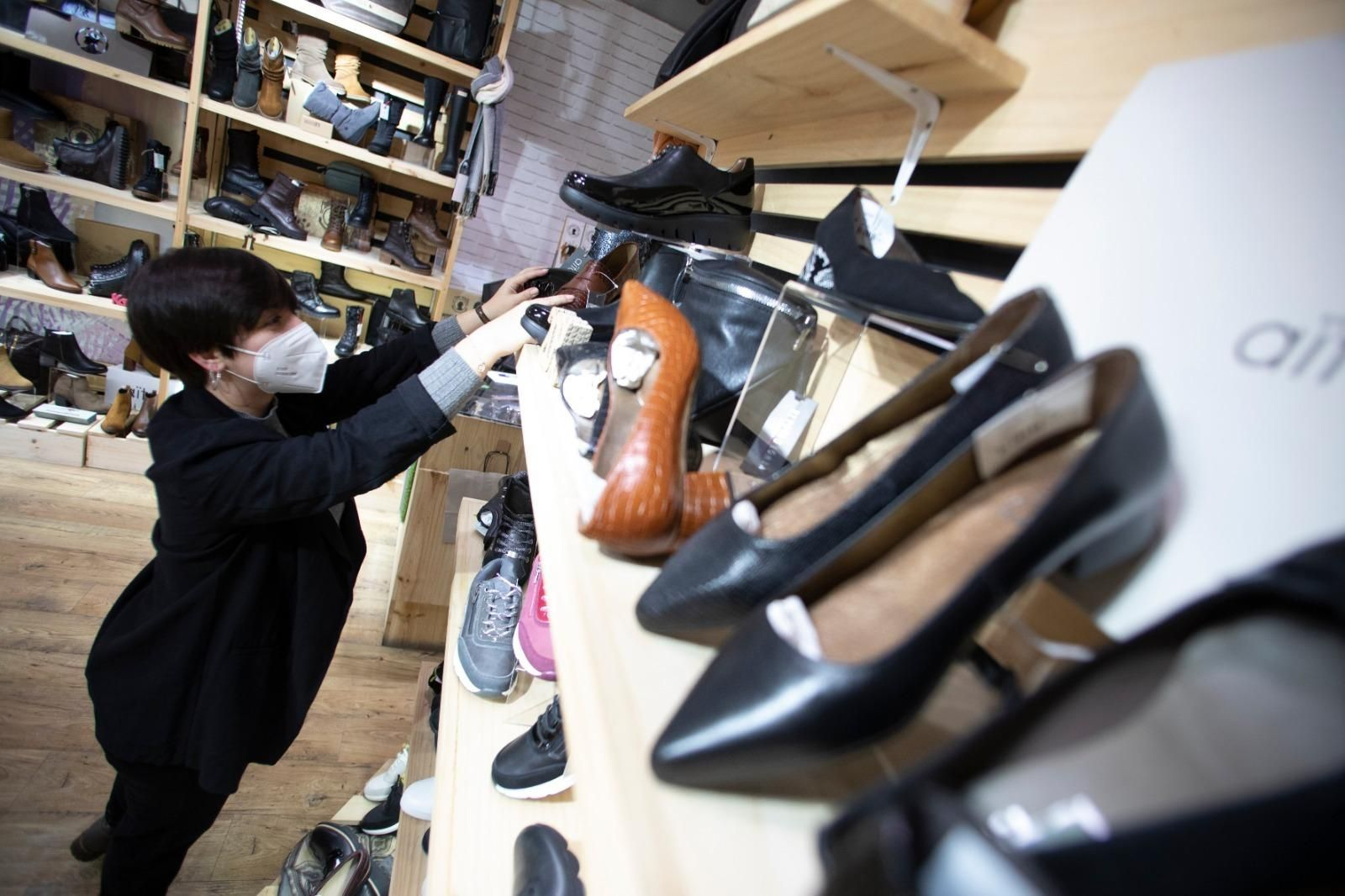 Carmen, de la zapatería Aïta, coloca el género en una estantería