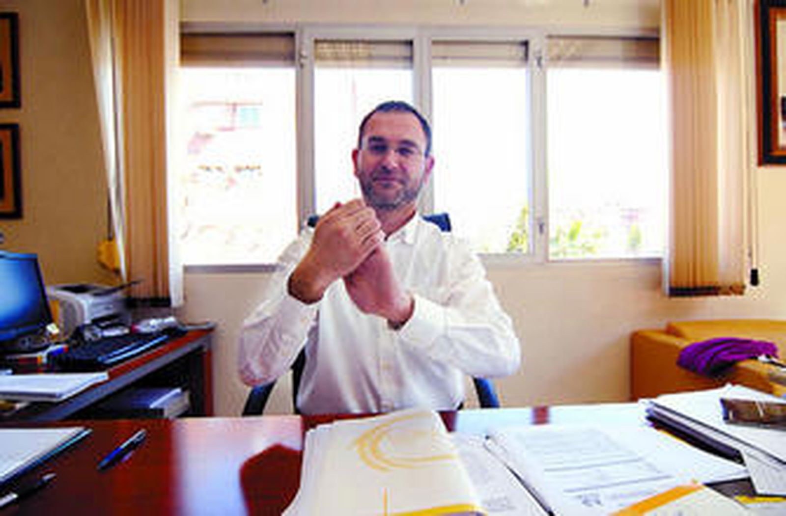 Alfredo Gómez, en su despacho, hace el signo de Andalucía en la lengua de las personas sordas.