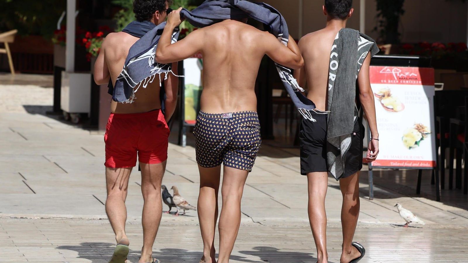 Varios jóvenes en bañador caminando por el centro de Málaga. Varios jóvenes en bañador caminando por el centro de Málaga.