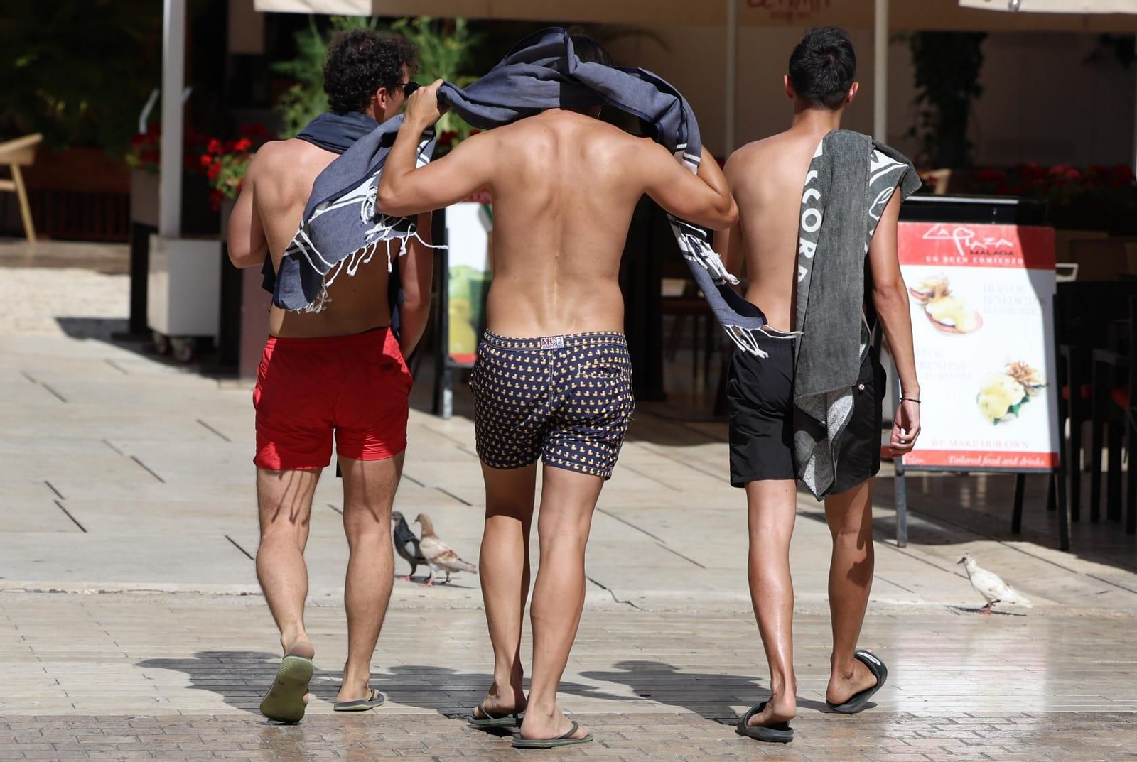 Varios jóvenes en bañador caminando por el centro de Málaga. Varios jóvenes en bañador caminando por el centro de Málaga.