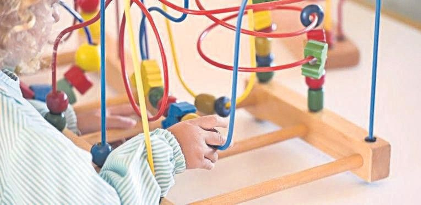 Una menor manipula un juguete educativo en una guardería.