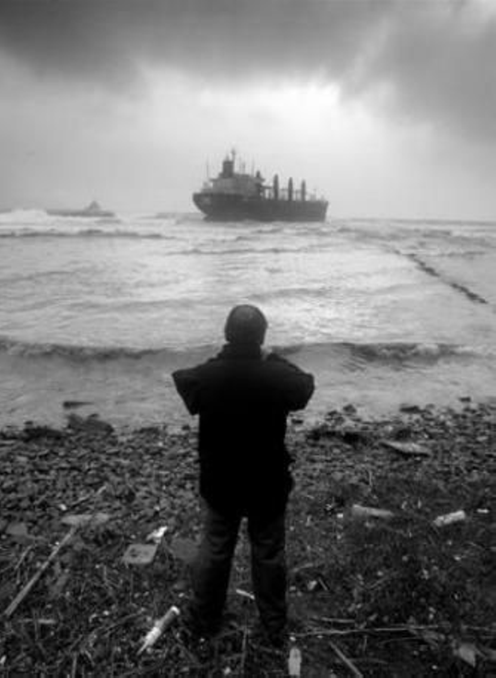 Un hombre observa el 'Tawe' encallado frente a la costa algecireña tras un fuerte temporal.