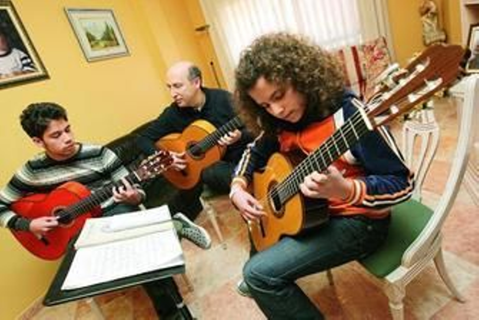 David, José y Gema tocan 'Entre dos aguas' en el amplio salón de su casa.