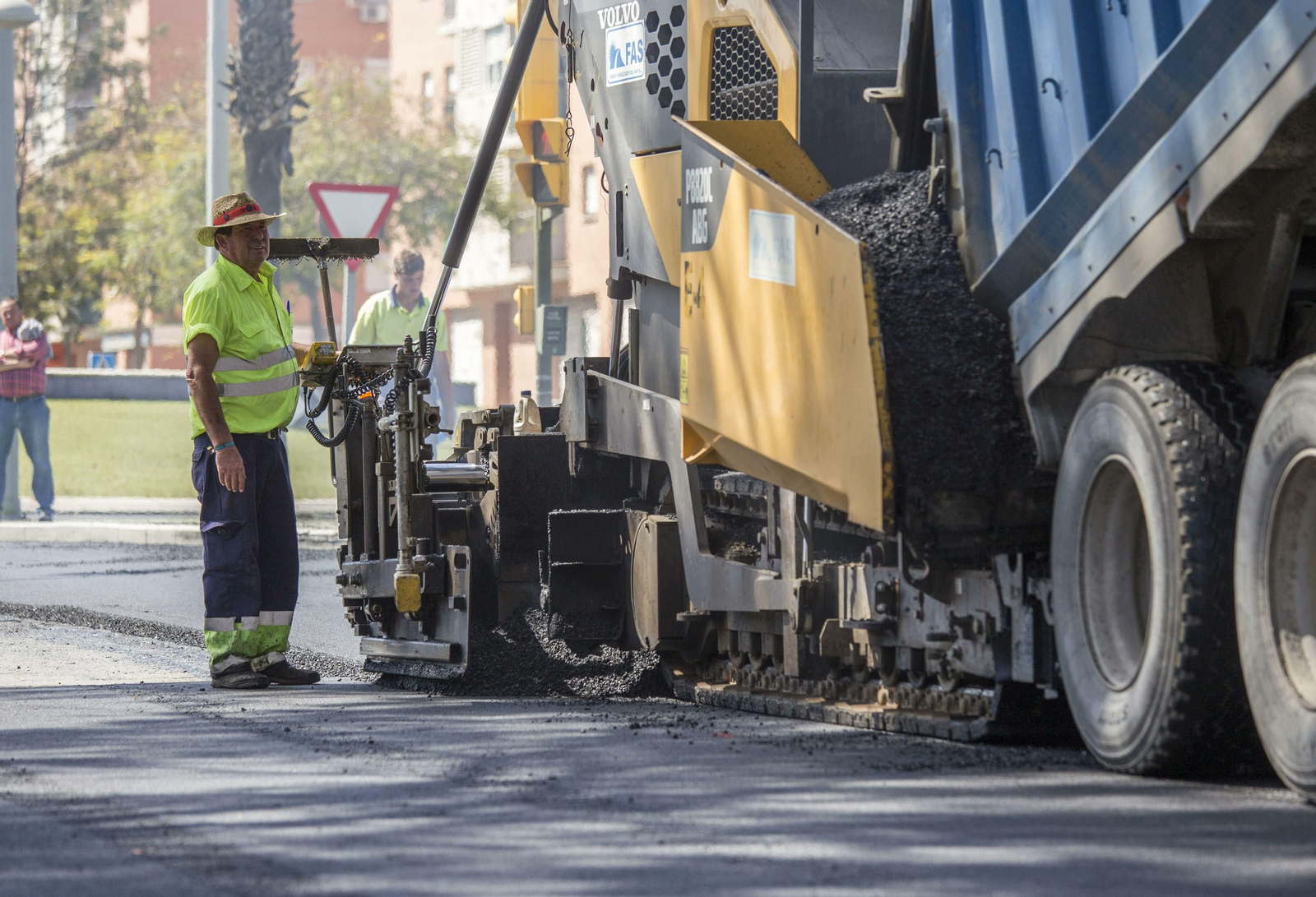 Operarios en los trabajos de asfaltado en una avenida de Huelva.