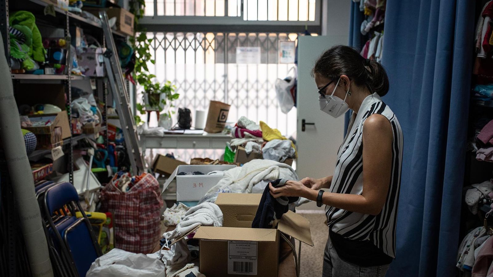 La sede de la fundación con una voluntaria clasificando ropa