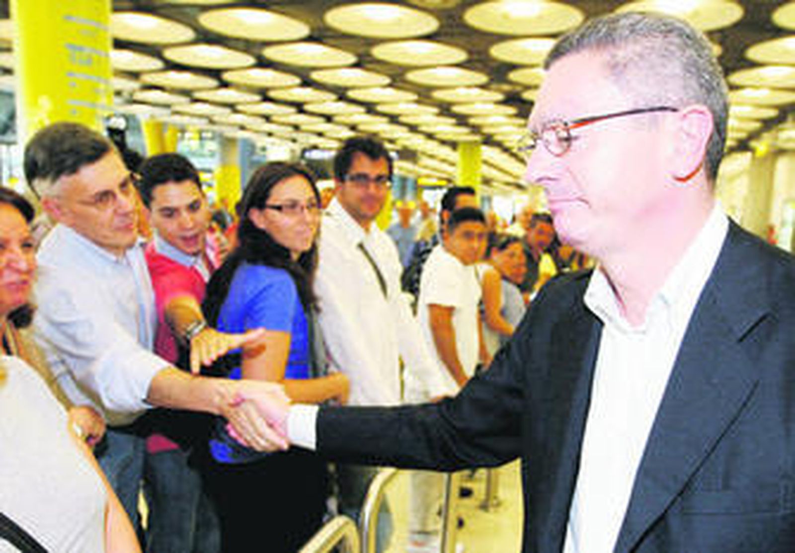 Alberto Ruiz-Gallardón saluda a su llegada al aeropuerto de Barajas.