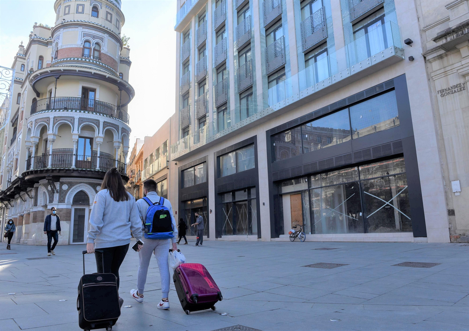 Turistas con maletas por la Avenida de la Constitución de Sevilla.