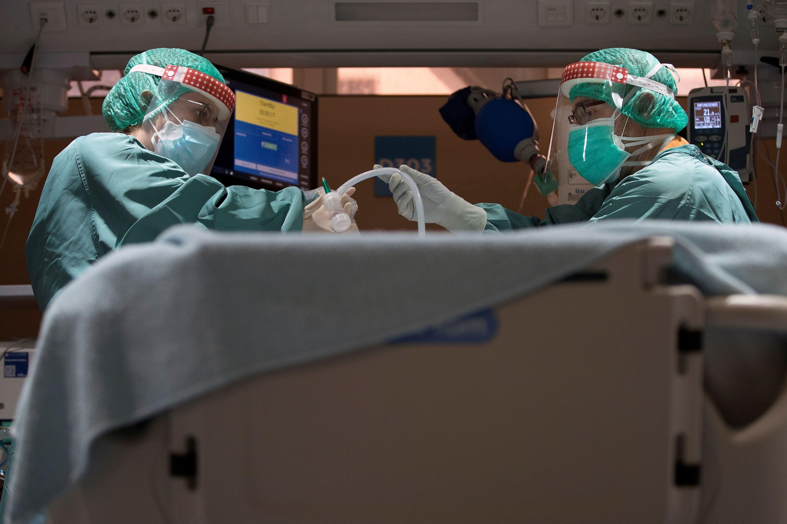 Dos profesionales sanitarios trabajan en la UCI de un hospital.