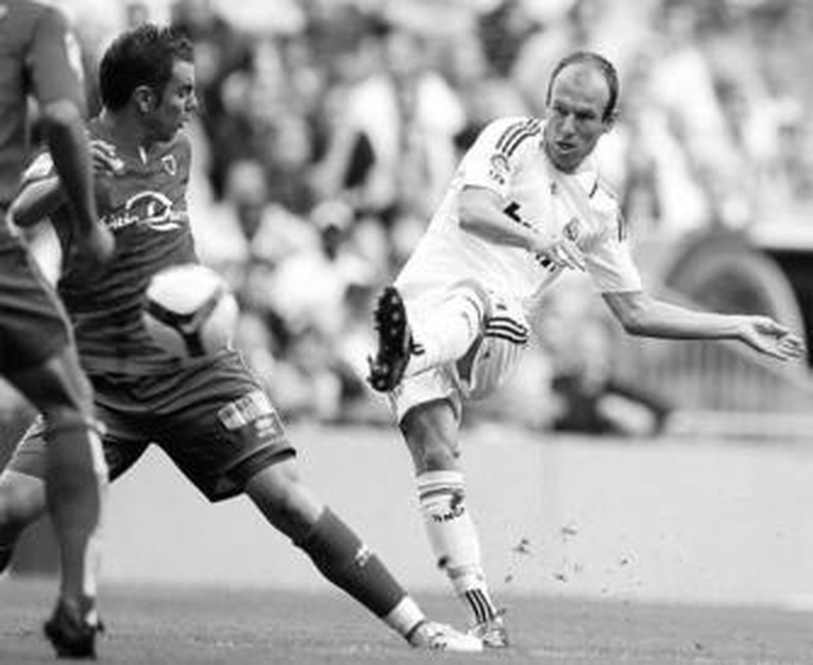 Robben intenta el lanzamiento ante dos jugadores del Numancia.