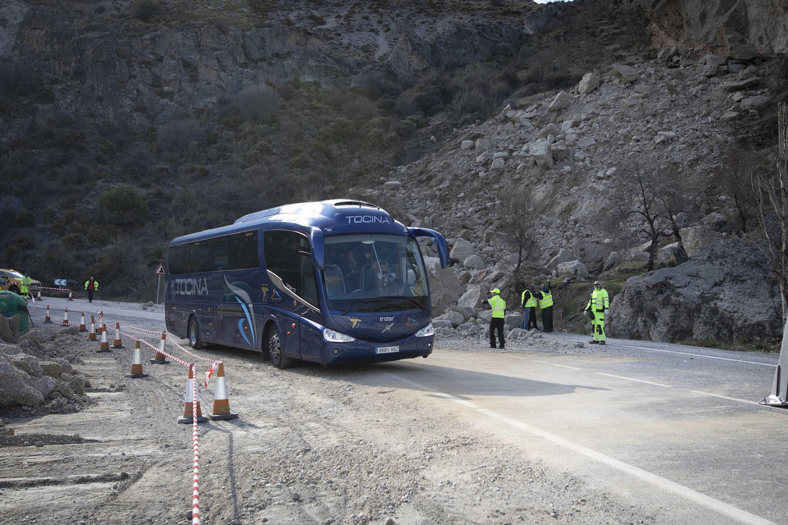 Un autobús transita por la zona afectada por el desprendimiento en la A395.
