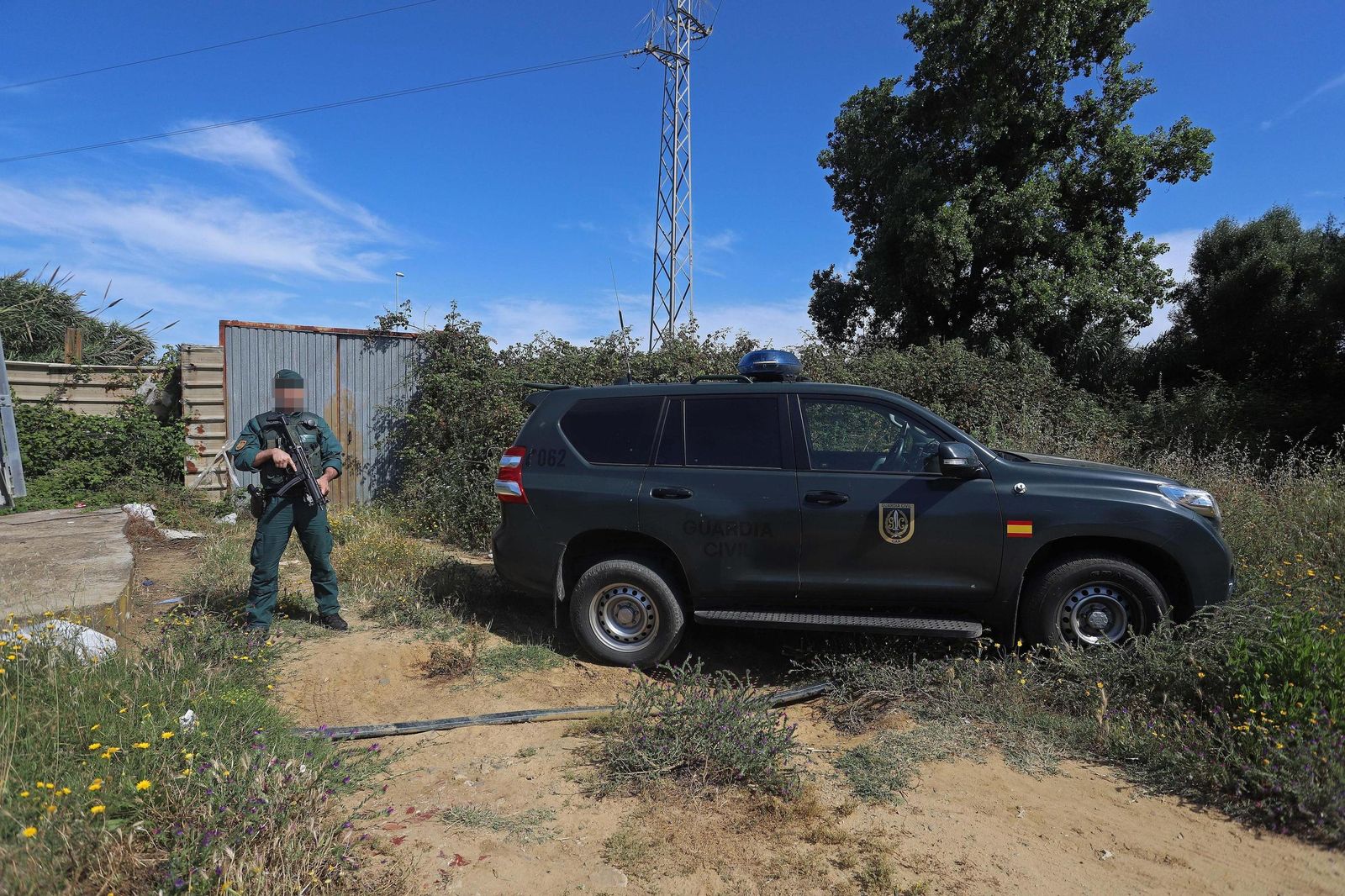 Un guardia civil custodia la entrada de la finca donde se hallaron los dos todoterreno robados en Guadarranque
