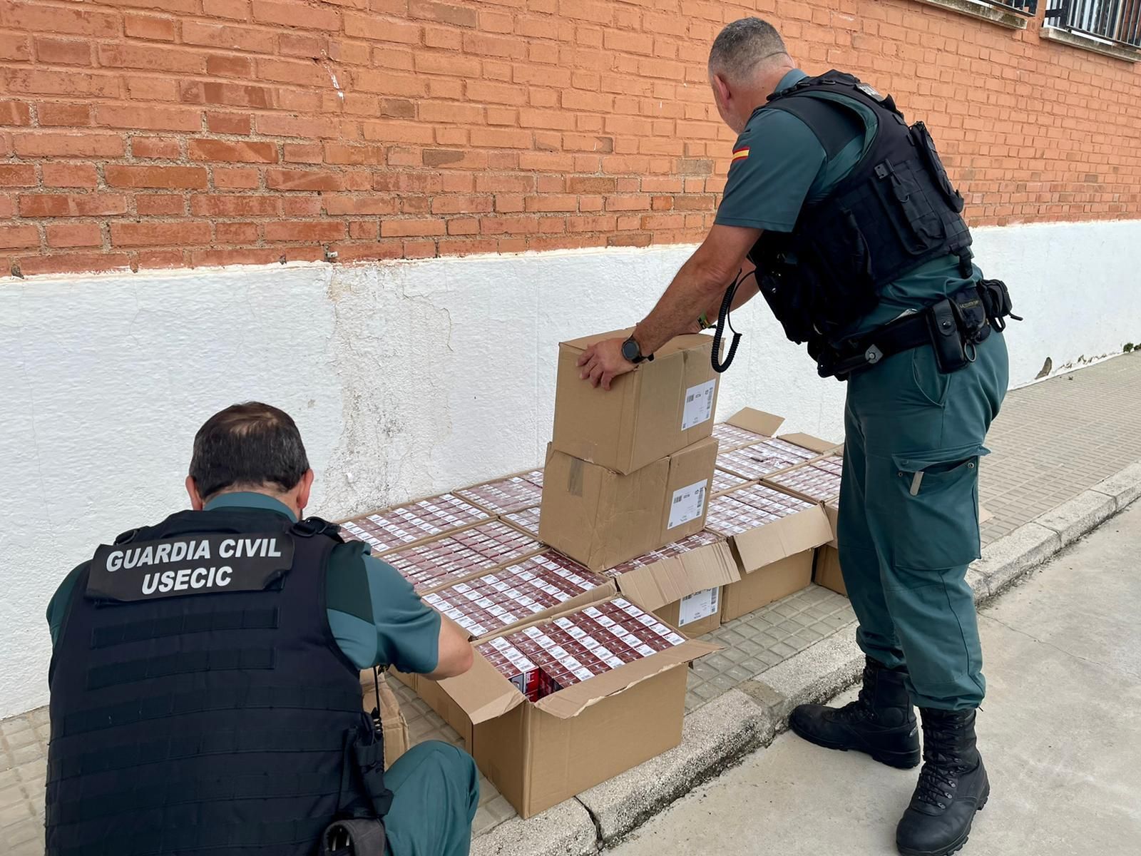 Los agentes, con el tabaco intervenido.