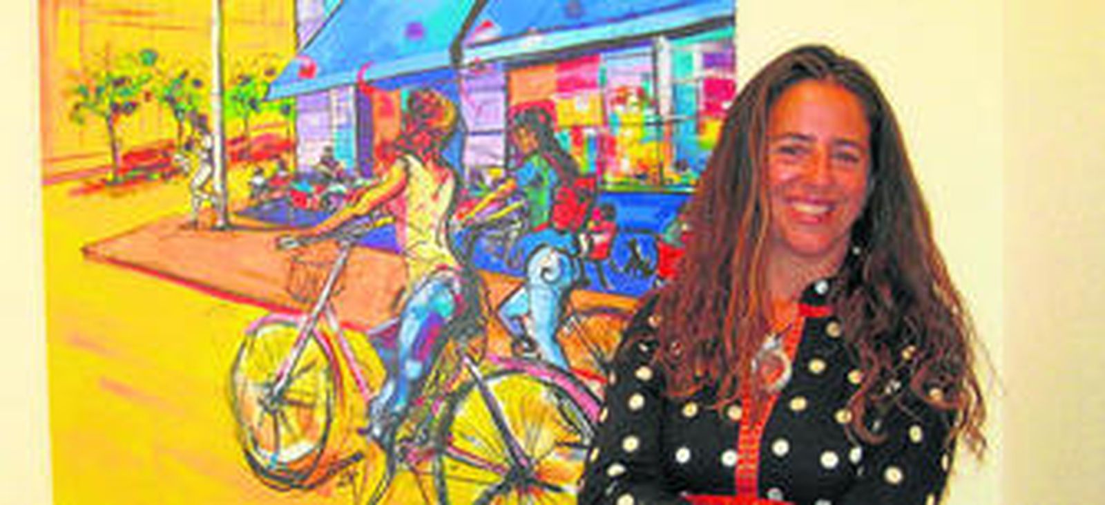 La artista posa junto a una de sus obras en la sala de la exposición.